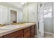 Bathroom showcasing dual sinks, tiled countertops, and decorative mirrors and hardware at 42350 Forest Oaks Dr, Elizabeth, CO 80107