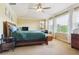 Bright bedroom featuring many windows, light yellow paint, and dark wood furniture at 42350 Forest Oaks Dr, Elizabeth, CO 80107
