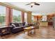Bright living room with hardwood floors, large windows, and an open view to the kitchen at 42350 Forest Oaks Dr, Elizabeth, CO 80107