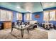Finished basement with bright blue walls, several windows and a comfortable seating area at 676 Hedgerow Way, Brighton, CO 80601