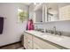 Bright bathroom showcasing a double sink vanity, two mirrors, and a window at 676 Hedgerow Way, Brighton, CO 80601