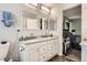 Bathroom featuring double sinks, vanity cabinets, and views into the bedroom at 676 Hedgerow Way, Brighton, CO 80601