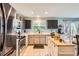 A spacious kitchen featuring stainless steel appliances, light countertops, and a kitchen island with a wooden top at 676 Hedgerow Way, Brighton, CO 80601