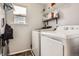 Efficient laundry room with a window, shelving, washer and dryer at 676 Hedgerow Way, Brighton, CO 80601
