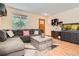 Comfortable living room featuring a large sectional, modern furnishings, and natural light at 676 Hedgerow Way, Brighton, CO 80601