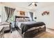 Comfortable bedroom with a dark wood bed frame, side tables, and artwork at 676 Hedgerow Way, Brighton, CO 80601