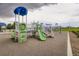 Community playground with green slides, climbing structures, and play areas providing a fun space for children to play at 676 Hedgerow Way, Brighton, CO 80601
