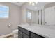 Bathroom featuring modern sink with gray cabinets and a decorative mirror with vanity lights at 26167 E Byers Pl, Aurora, CO 80018