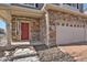 Welcoming front entrance boasting stone accents, a red door, a covered porch, and modern railings at 26167 E Byers Pl, Aurora, CO 80018