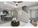 A spacious living room featuring a kitchen, a dining area, and a stylish staircase at 26167 E Byers Pl, Aurora, CO 80018