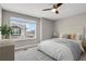 Comfortable main bedroom featuring a plush bed, a ceiling fan and a window with neighborhood views at 26167 E Byers Pl, Aurora, CO 80018