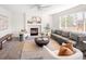 Cozy living room with a fireplace, large windows, and neutral tones at 9741 Moss Rose Cir, Highlands Ranch, CO 80129