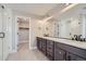 Bathroom featuring a double vanity, modern fixtures, and a glass-enclosed shower at 2443 W 69Th Pl, Denver, CO 80221