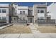 Modern townhome showcasing contemporary design and a welcoming front entrance, complemented by stone and siding accents at 2443 W 69Th Pl, Denver, CO 80221