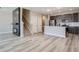 Open-concept space with a fireplace, staircase, and a modern kitchen with stainless steel appliances at 2443 W 69Th Pl, Denver, CO 80221