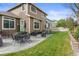 Spacious backyard featuring a stone patio, lush lawn, mature trees, and privacy landscaping at 17297 Opal Hill Dr, Parker, CO 80134