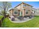 Charming backyard with a stone patio, lush lawn, and outdoor dining set, perfect for relaxing and enjoying the outdoors at 17297 Opal Hill Dr, Parker, CO 80134