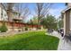 A lush, green backyard featuring a stone patio, wooden fence, and mature trees creating a private outdoor space at 17297 Opal Hill Dr, Parker, CO 80134