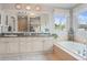 Bright bathroom with double vanity, granite countertop, large mirror, and soaking tub at 17297 Opal Hill Dr, Parker, CO 80134