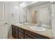 Bathroom with double sinks, dark vanity, granite countertop, and large mirror for a luxurious experience at 2562 S Kendrick St, Denver, CO 80228