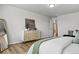 Bright bedroom features a white comforter, wood floors, and modern dresser with decor at 2562 S Kendrick St, Denver, CO 80228