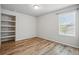 Bedroom with hardwood floors, natural light from the window, and built-in shelving for extra storage at 2562 S Kendrick St, Denver, CO 80228