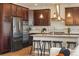 Modern kitchen with stainless steel appliances, granite countertops, dark wood cabinets, and an island with seating at 2562 S Kendrick St, Denver, CO 80228
