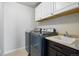 Convenient laundry room with modern washer and dryer, sink, countertop, and upper cabinets at 2562 S Kendrick St, Denver, CO 80228