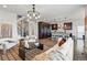 Open concept living room with hardwood floors, modern lighting fixtures, and a seamless flow into the kitchen at 2562 S Kendrick St, Denver, CO 80228