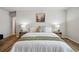 Bright main bedroom featuring hardwood floors, neutral walls, and decorative bedside lamps and tables at 2562 S Kendrick St, Denver, CO 80228
