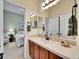 Bathroom vanity with sink, decorative mirror and tile, and access to carpeted bedroom at 2571 Hunters Pl, Highlands Ranch, CO 80129