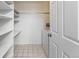 Bright laundry area with tiled floor, open shelving and washer at 7000 E Quincy Ave # 204, Denver, CO 80237