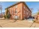 Exterior view of a well-maintained red brick building with ample parking and tidy landscaping at 1201 Balsam Ave # 203, Boulder, CO 80304