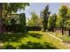 Beautiful green backyard showing lush grass, trees, and a fence line for privacy at 100 N Gaylord St, Denver, CO 80206