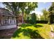 Large green backyard featuring a Tudor-style studio and tree-covered brick house at 100 N Gaylord St, Denver, CO 80206