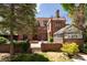 Exterior of brick house with a patio, greenhouse, and beautifully landscaped yard at 100 N Gaylord St, Denver, CO 80206