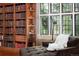 Comfortable bedroom sitting area with custom built-in bookcases and natural light at 100 N Gaylord St, Denver, CO 80206