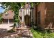 Elegant Tudor-style home with a brick exterior, a wooden front door, and lush greenery at 100 N Gaylord St, Denver, CO 80206