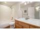 Full bathroom with shower over tub, white tile and wood vanity at 1405 Castlepoint Circle, Castle Pines, CO 80108