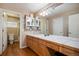 Full bathroom features double sinks, wood cabinets, a large mirror, and a shower at 1405 Castlepoint Circle, Castle Pines, CO 80108