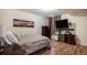 Cozy bedroom with wood floors, dresser, mounted TV, and ambient lighting at 1405 Castlepoint Circle, Castle Pines, CO 80108