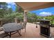 Outdoor wooden deck complete with dining table and a grill, with serene greenery views at 1405 Castlepoint Circle, Castle Pines, CO 80108