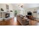 Spacious living room with a stone fireplace, hardwood floors, and sliding door to patio at 1405 Castlepoint Circle, Castle Pines, CO 80108
