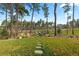 Lush backyard features a stone walkway leading to an outdoor seating area surrounded by trees at 1734 Summerglow Ln, Monument, CO 80132