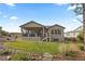 Well-maintained backyard with a covered patio, steps to yard, and stone walkway at 1734 Summerglow Ln, Monument, CO 80132
