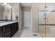 Bright bathroom with double vanity, modern fixtures, and glass-enclosed shower with a built-in bench at 1734 Summerglow Ln, Monument, CO 80132