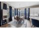Inviting dining area with large windows, hardwood floors, modern lighting and stylish blue curtains at 1734 Summerglow Ln, Monument, CO 80132