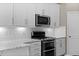 Modern kitchen featuring stainless steel appliances, white cabinets, and granite countertops at 1734 Summerglow Ln, Monument, CO 80132