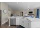 Modern kitchen island with stainless steel dishwasher and undermount sink overlooking living area at 1734 Summerglow Ln, Monument, CO 80132