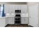Modern kitchen with stainless steel appliances, white cabinetry, and elegant countertops at 1734 Summerglow Ln, Monument, CO 80132